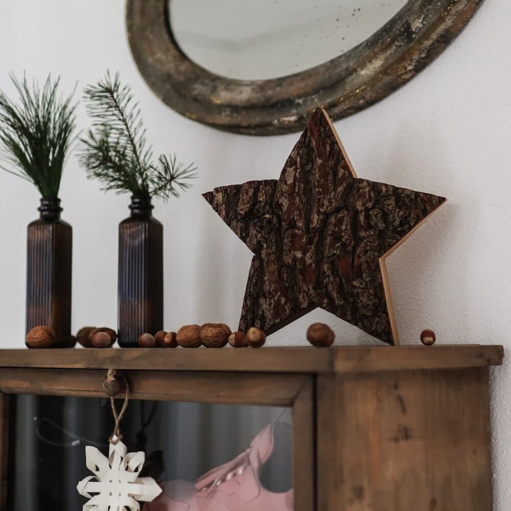 Hoteldekoration Rindenstern - schöne handgemachte Sterne dekoriert auf einem urigen Sideboard