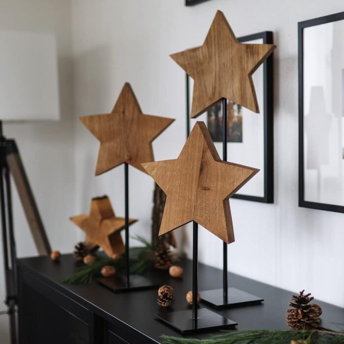 Drei Holzsterne handgemacht aus Eichenholz - auf schwarze Metallständer gesetzt - schöne Weihnachtsdeko für Hotels